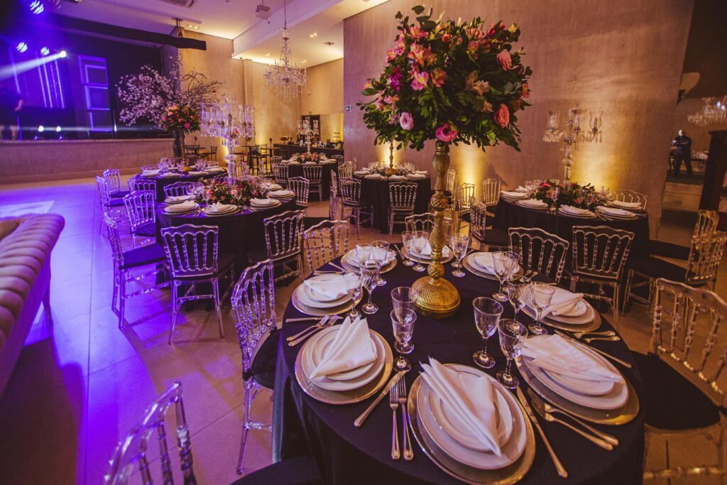 Lavish dining room setup featuring floral arrangements, elegant table settings, and ambient lighting for a private function.